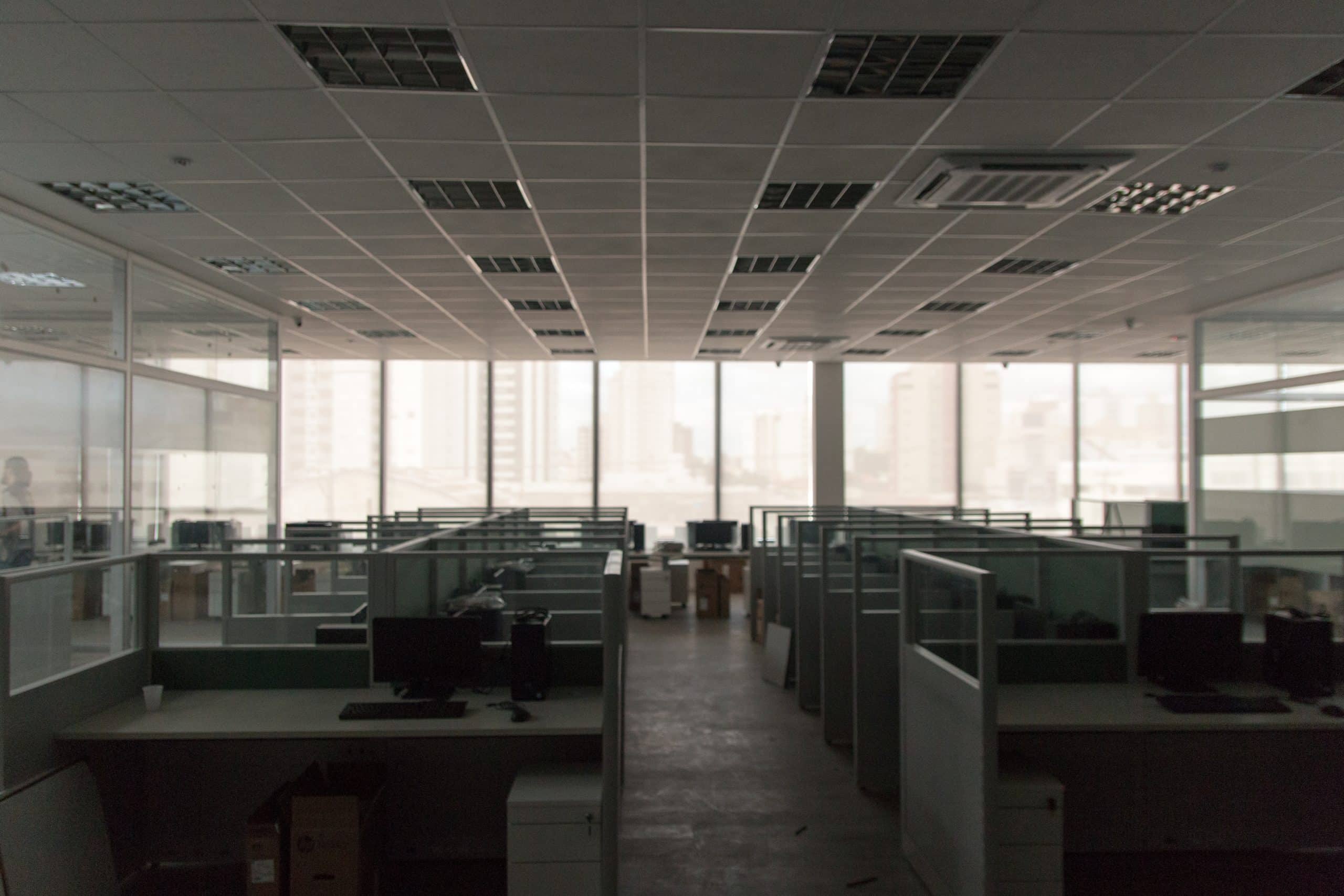 Empty office interior with desks and ceiling lights