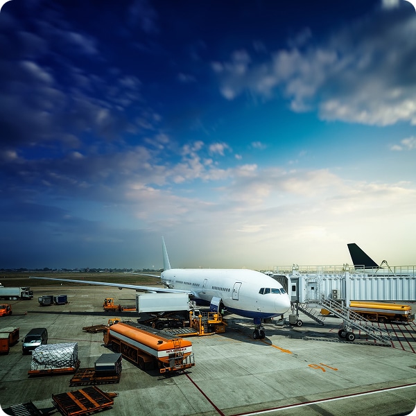 Commercial airplane parked at an airport gate with ground service vehicles