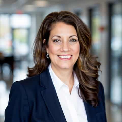 Professional headshot of Laura Aiuppa wearing a white shirt and dark blazer indoors