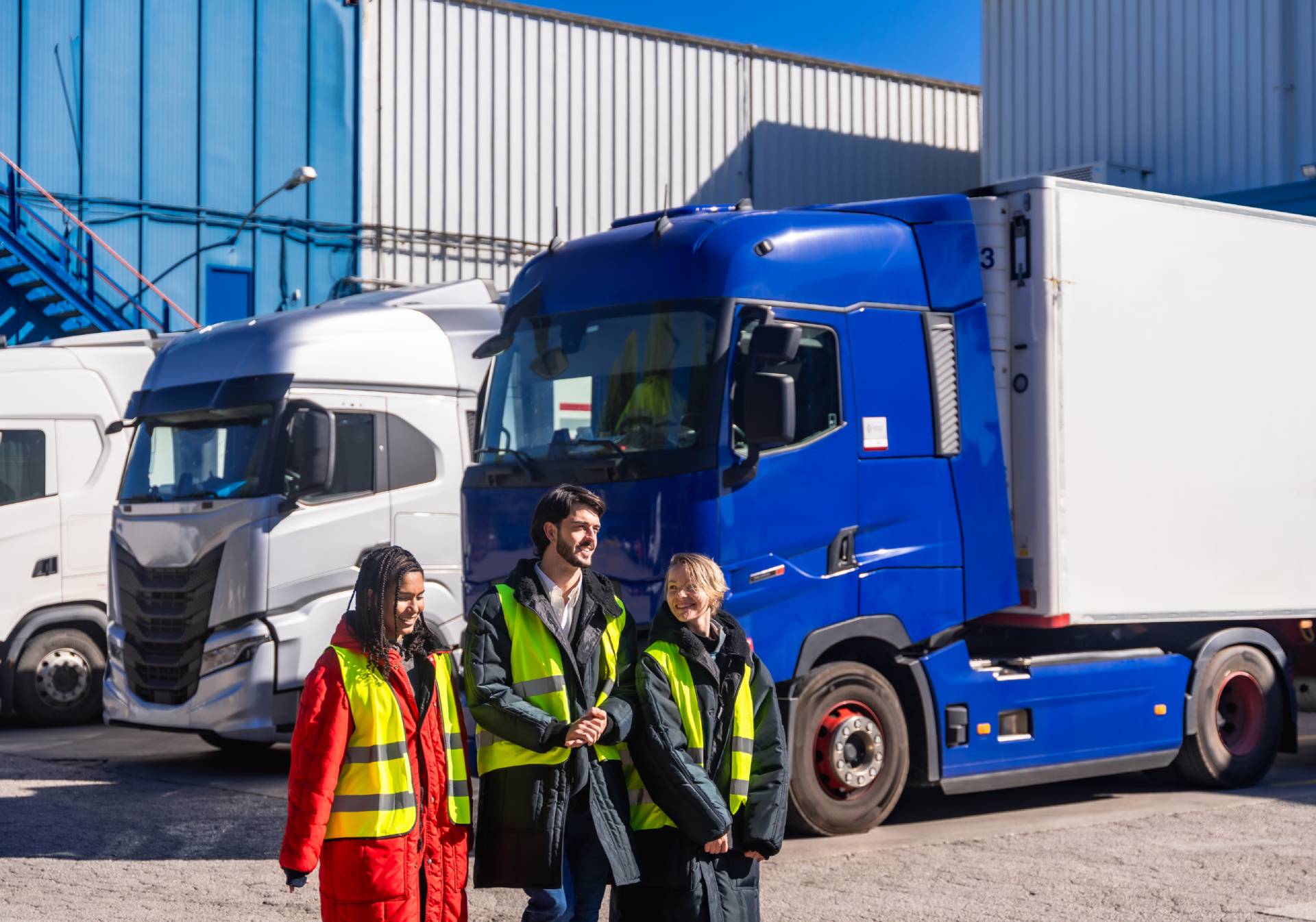 Truck drivers standing beside blue semi-truck