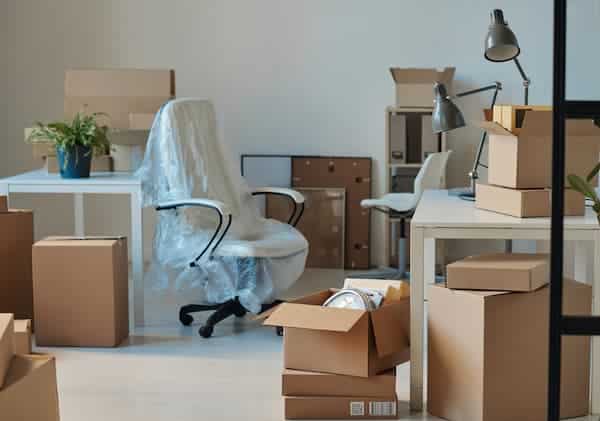 Home office setup with packed moving boxes
