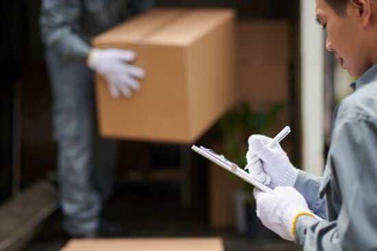 Gloved hands holding a cardboard box