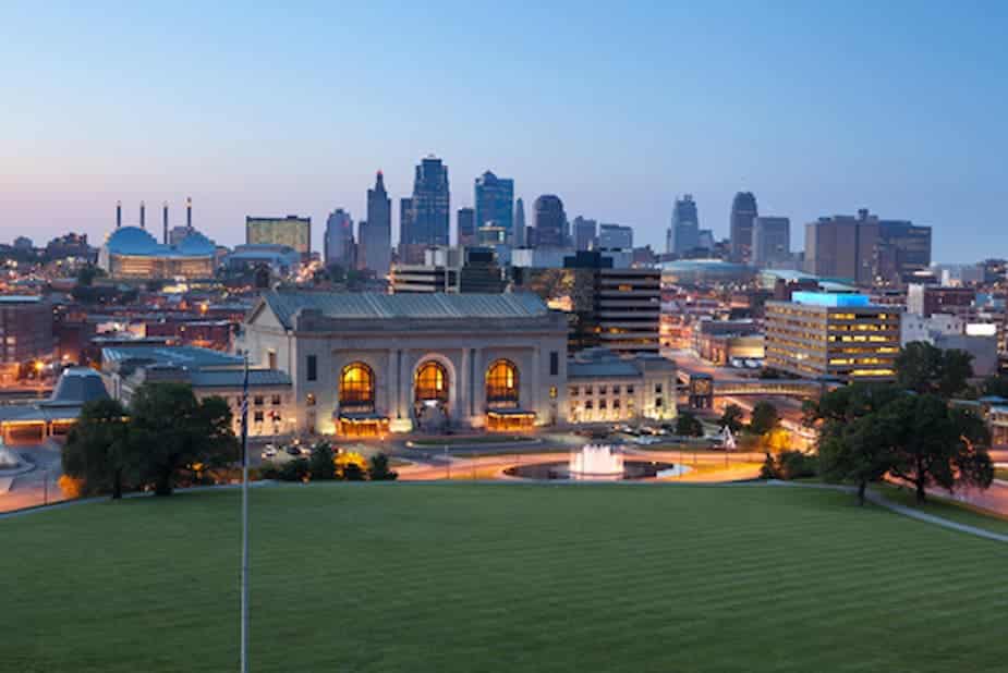 Kansas City skyline at dusk with a historic train station and illuminated downtown buildings